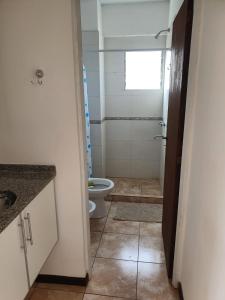 a small bathroom with a toilet and a window at Departamento Augusta II in Posadas