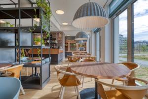 a restaurant with tables and chairs and windows at B&B HOTEL Antwerpen Zuid in Antwerp
