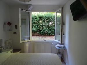Schlafzimmer mit einem Bett und einem Fenster in der Unterkunft Le Hameau in Mutzig