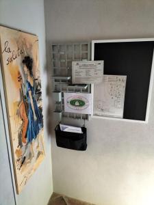 una habitación con una pared con certificados y carteles. en LOCANDA LA SALITA, en Monforte dʼAlba