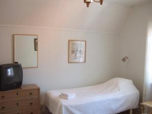 a bedroom with a bed and a tv and a dresser at Rönninge Gård in Rönninge