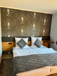 ケーヴェラアーにあるPension auf dem Landのベッドルーム1室(ベッド1台付)が備わります。壁は金の壁紙を使用しています。