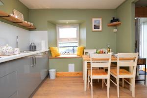 a kitchen with a table and chairs in a room at Chapelton Cottage in Strachur