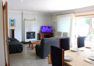 un soggiorno con TV e tavolo con sedie di MyStay - Villa Luísa a Vila do Conde
