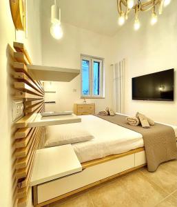 a bedroom with a large bed and a flat screen tv at Casa Perricci - short lets - Monopoli (BA) in Monopoli