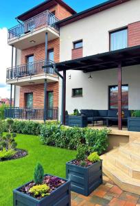 a house with a patio with plants in a yard at Várkonyi Apartman in Gyula