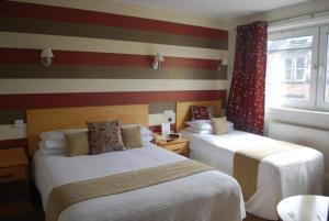 Un pat sau paturi într-o cameră la New County Hotel