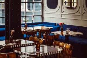 a restaurant with tables and chairs and a blue couch at Hotel Panache in Paris