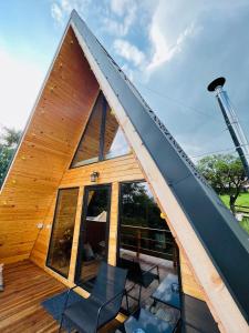 una casa marco con techo con sillas en una terraza en CABANA 365 en Brasov