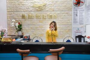 a woman standing behind a table talking on a phone at My Anh Boutique Villa Hoi An in Hoi An +41 photos
