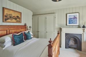 a bedroom with a bed and a fireplace at Harold House in Cowes