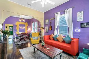 uma sala de estar com um sofá vermelho e uma parede roxa em FRIENDS AIRBNB Themed 2bed 2bath walkable to all of Ybor em Tampa