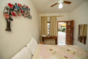 una camera da letto con un letto e un vaso di fiori sul muro di Pousada Boa Vista a Tiradentes Altre 80 foto