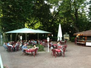 a group of people sitting at tables at an outdoor restaurant at Hotel Restaurant Blumenhof in Baesweiler