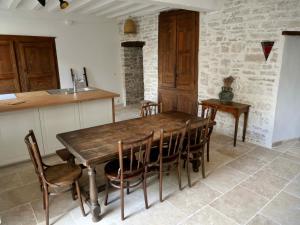 a dining room with a wooden table and chairs at Grande maison - village de Noyers - 5 chambres in Noyers-sur-Serein