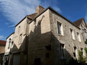 an old brick building with its shadow on the side at Grande maison - village de Noyers - 5 chambres in Noyers-sur-Serein
