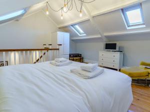 a bedroom with a large white bed with two towels on it at The Cottage-uk32854 in Alltwen