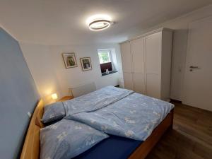 a bedroom with a bed with a blue comforter at a Bäckesch 15 in Nettersheim