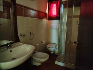 a bathroom with a sink and a toilet and a shower at Albis Harena - Porto Antigo 2 in Santa Maria