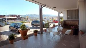 a patio with white chairs and a view of a parking lot at Hotel Al Sant'Andrea in Sarzana