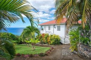 una casa bianca con vista sull'oceano di Caribbean Sea View Holiday Apartments a Méro