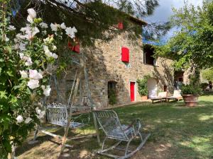 a garden with two chairs in front of a building at Il Fiorino di Badia in Badia A Passignano