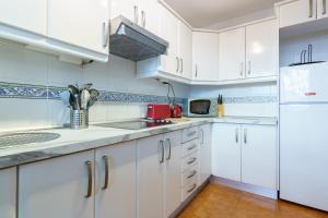 kuchnia z białymi szafkami, zlewem i lodówką w obiekcie Apartamento Mijas Golf w mieście Mijas