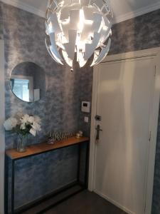 corridoio con specchio e lampadario pendente di La casa di Deborah a Namur