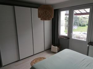 a bedroom with white wardrobes and a window at La casa di Deborah in Namur