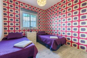 sypialnia z 2 łóżkami i czerwono-białą ścianą w obiekcie Apartamento Mijas Golf w mieście Mijas