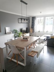 sala de estar con mesa de madera y sillas en La casa di Deborah, en Namur