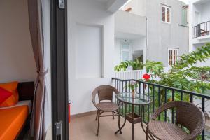 a balcony with a table and chairs and a couch at My Anh Boutique Villa Hoi An in Hoi An