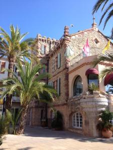 Un edificio con palmeras delante. en Mas Provençal, en Le Lavandou