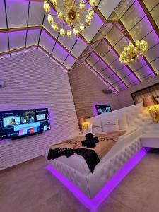 a bedroom with a large white bed with purple lighting at Hotel Ramka & Restaurant & Wine Bar in Poznań