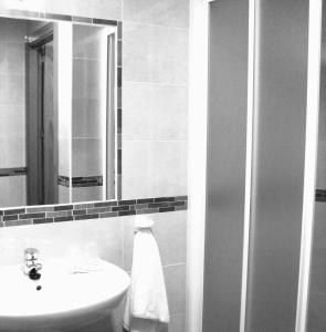 y baño con lavabo y espejo. en Hostal Granado, en Madrid