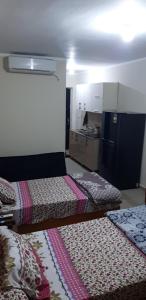 a room with two beds and a kitchen in it at Studio apartment, Aqua View Resort, North coast in El Alamein