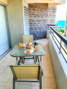 a table with a plate of food on a balcony at Eden Sea Breeze, 1 bed, Rooftop Pool, Gym in Limassol