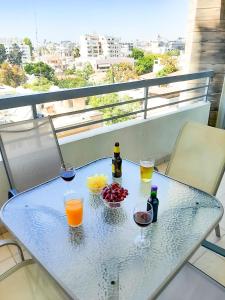 a table with drinks and fruit on a balcony at Eden Sea Breeze, 1 bed, Rooftop Pool, Gym in Limassol