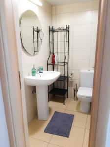 a bathroom with a sink and a toilet and a mirror at Eden Sea Breeze, 1 bed, Rooftop Pool, Gym in Limassol