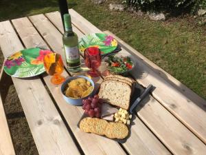 a picnic table with a plate of food and a bottle of wine at Hillside in St Austell