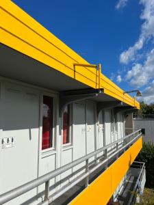 um edifício amarelo e branco com uma varanda em Premiere Classe Dunkerque Saint Pol Sur Mer em Saint-Pol-sur-Mer