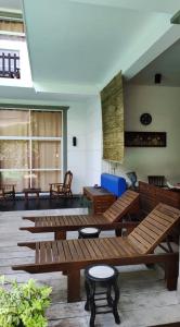 Nil Diya Beach Resort في ماتارا: غرفة مع العديد من المقاعد والطاولات الخشبية