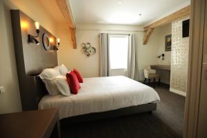 Habitación de hotel con cama con almohadas rojas en Ferme du Roy, en Anserville