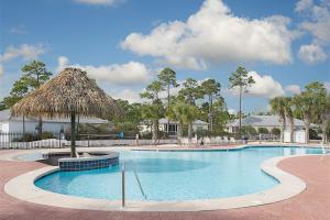 una gran piscina con sombrilla de paja en The Rookery #3002, en Gulf Shores