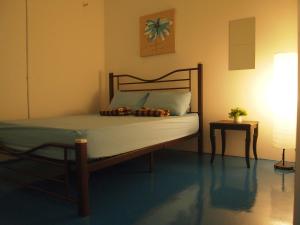 a bed in a room with a lamp and a table at The Cardamom Hostel in Melaka