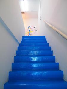a stair case with blue stairs in a room at The Cardamom Hostel in Melaka