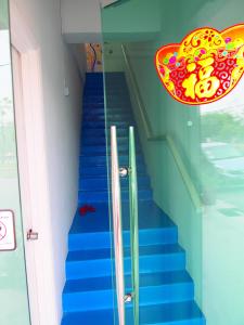 un conjunto de escaleras azules con una tabla de surf en The Cardamom Hostel, en Melaka