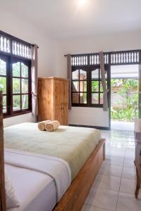 a bedroom with a bed with two wooden slippers on it at Sandora Homestay with Private Pool by Supala in Ubud