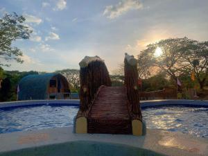 un puente de madera en medio de una piscina en Don Roberto's Kubo Resort, en Nasugbu
