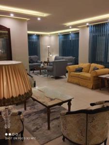 a living room with couches and tables in a room at Black Iris Hotel II in Madaba